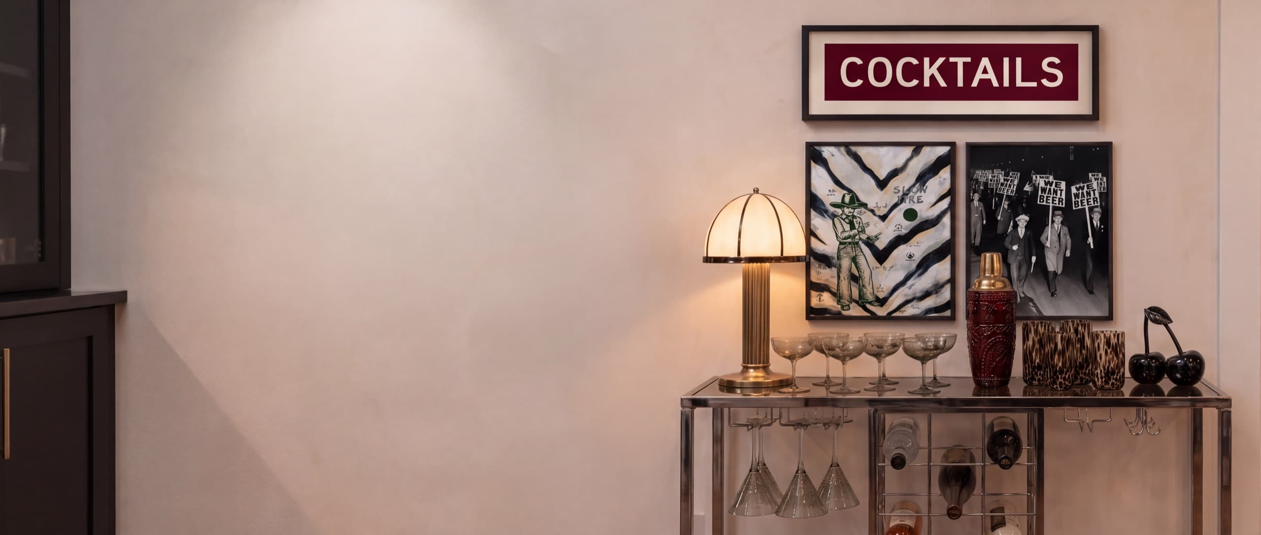 Styled bar cart and gallery wall in a warm living room corner