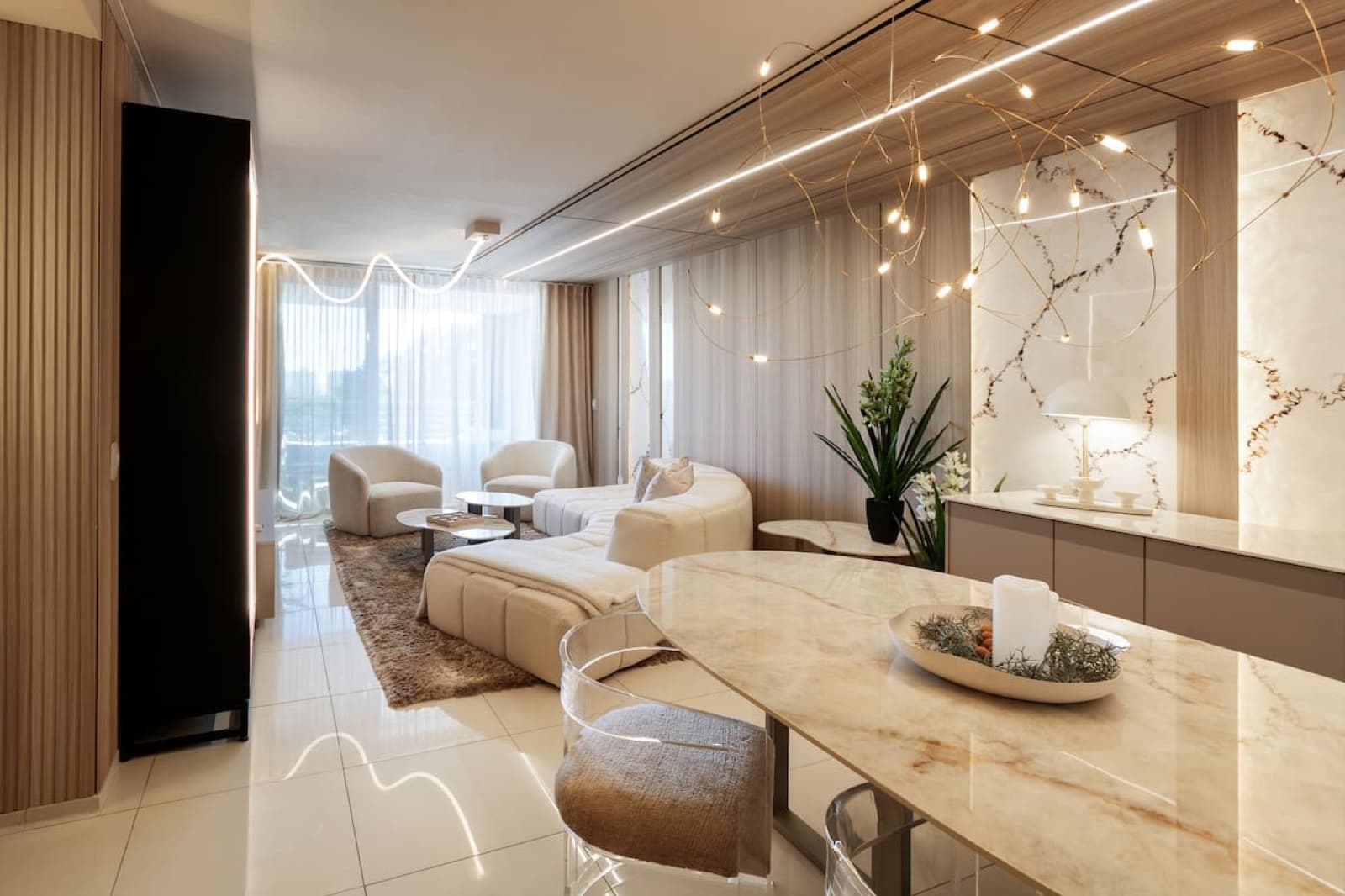Living and dining area with sculptural string lighting and a marble table