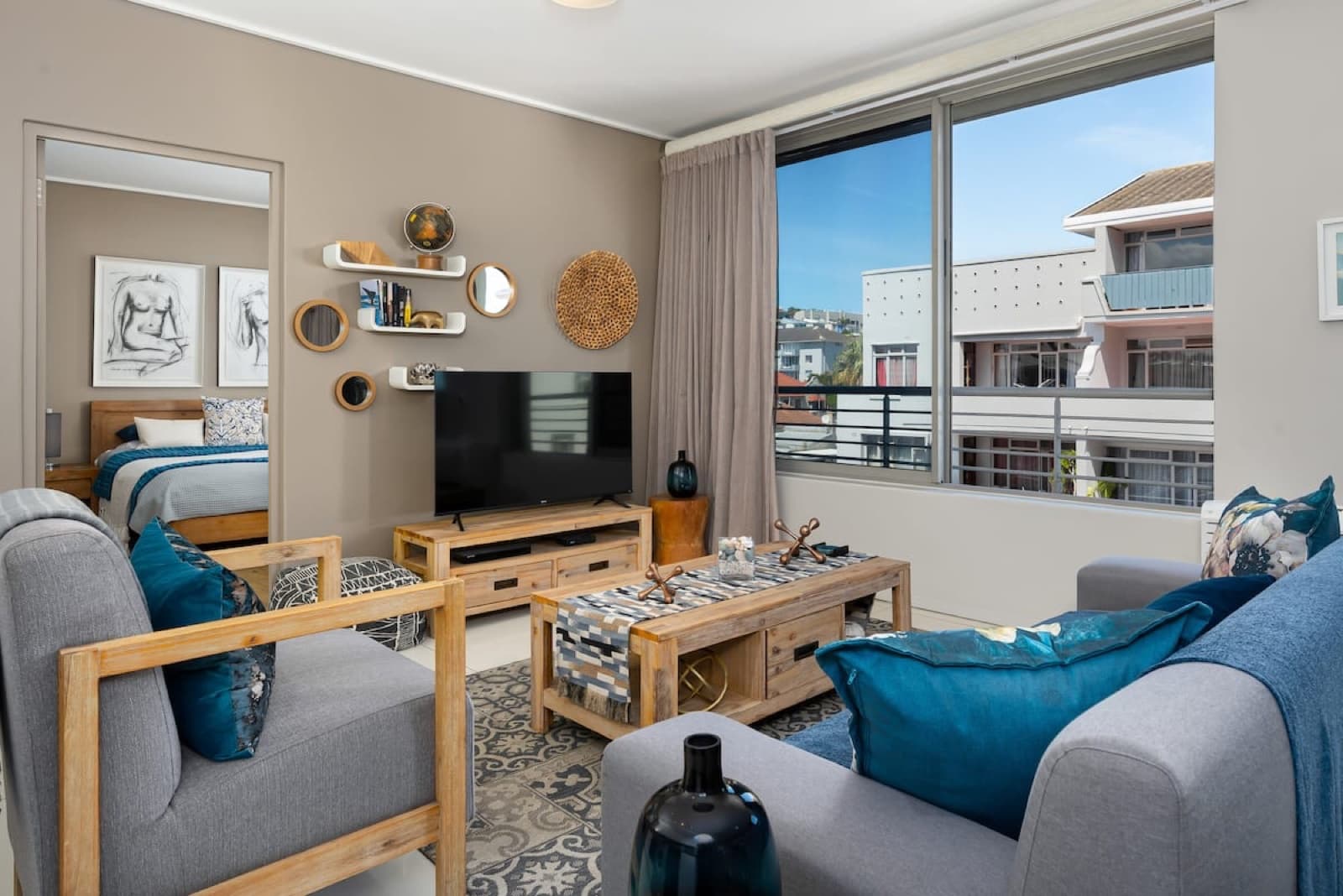 Living room with gray armchairs, gallery wall, and city view