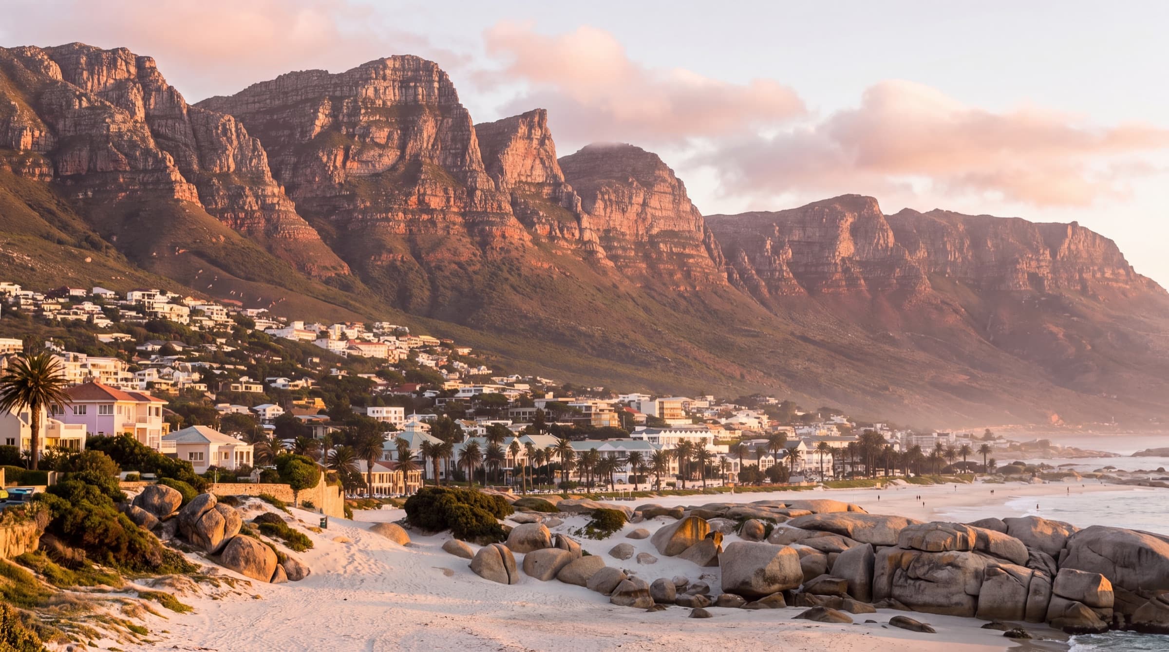 Camps Bay coastline at golden hour, with the Twelve Apostles mountains behind the beachfront